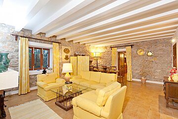 A living room with yellow furniture and a glass coffee table