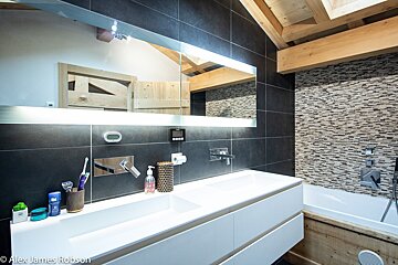 A bathroom with two sinks and a large mirror by alex james robson
