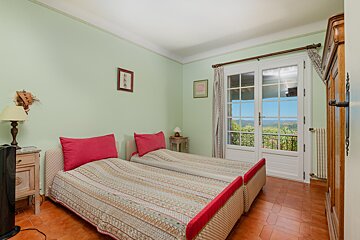 A bedroom with two beds and a large window