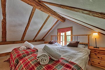 A bedroom with two beds and a lamp