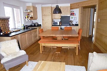 A kitchen and dining area with a table and chairs