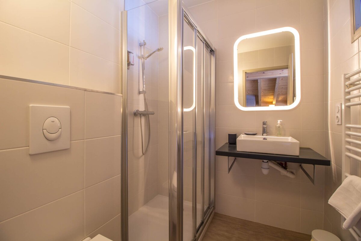 A bathroom with a sink a shower and a mirror