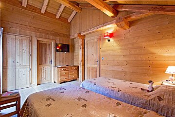 A bedroom with two beds a dresser and a television