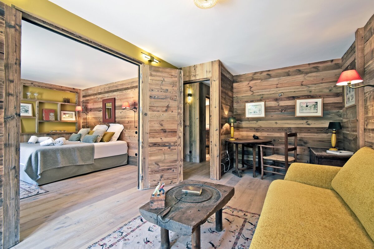 A bedroom with wood paneling and a yellow couch