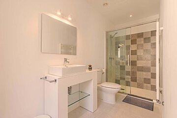 A bathroom with a toilet a sink and a mirror