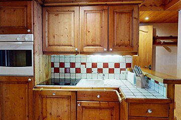 A kitchen with wooden cabinets and a stove top oven