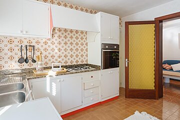 A kitchen with white cabinets and a yellow door