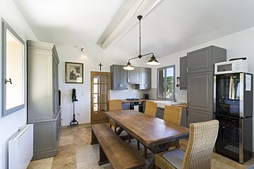 A kitchen with a table and chairs and a microwave