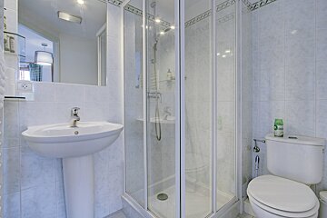 A bathroom with a toilet a sink and a shower