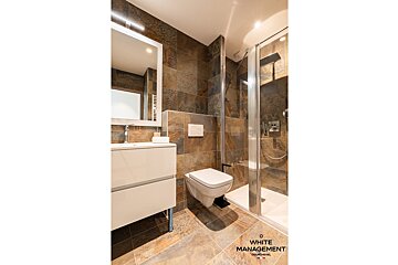 A bedroom with wood paneling and a large bed