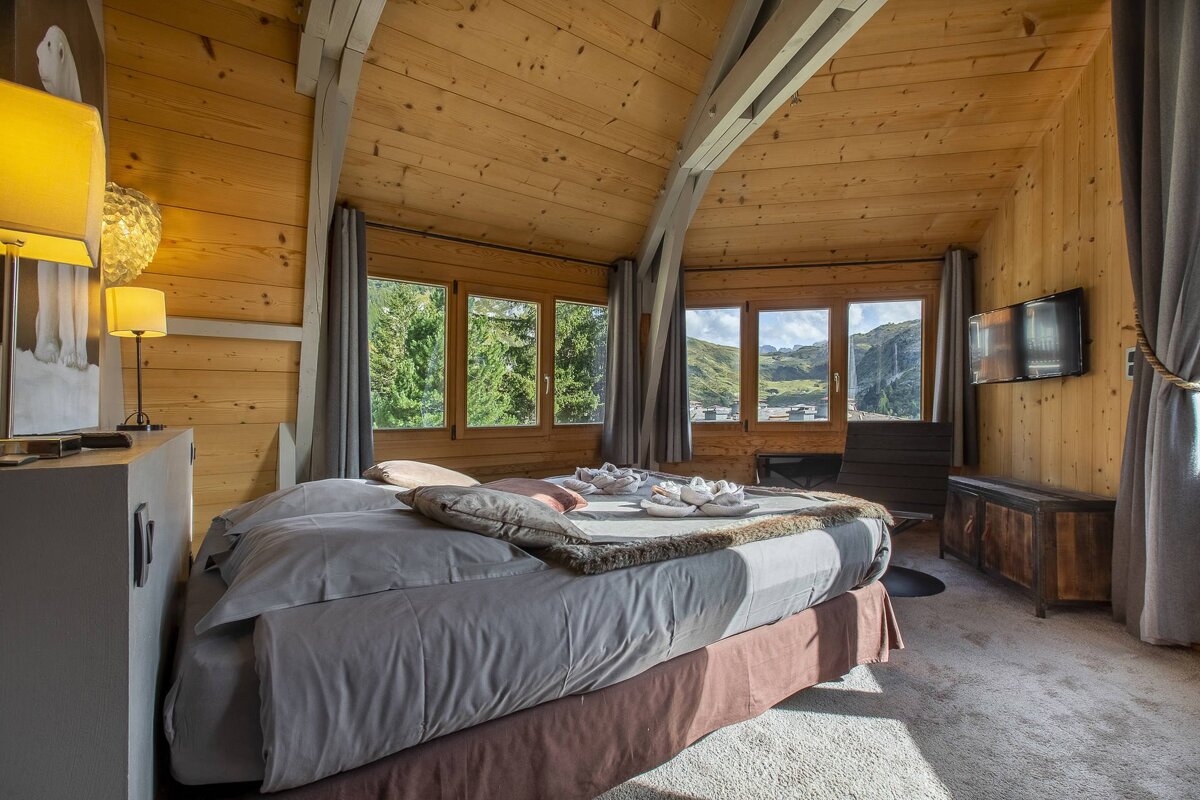 A bedroom with a large bed and a flat screen tv