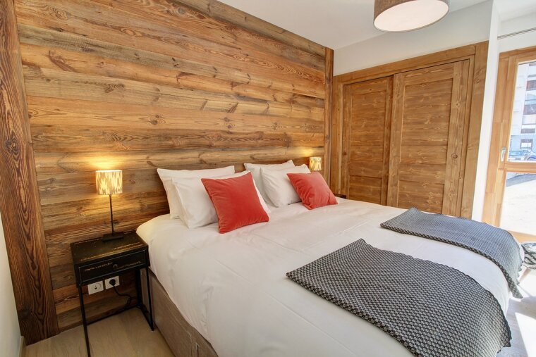 A bedroom with a bed and a wooden wall
