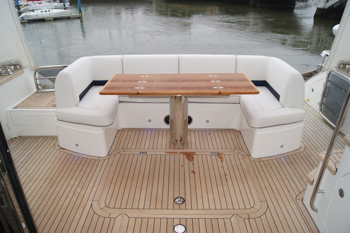 A boat with a wooden table and white seats