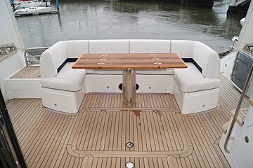 A boat with a wooden table and white seats