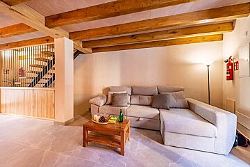 A living room with a couch and a fire extinguisher on the wall