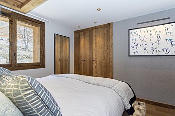 A bedroom with a bed and a picture on the wall