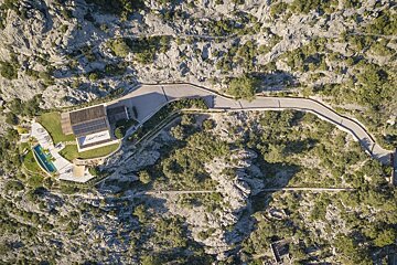 An aerial view of a house on the side of a mountain