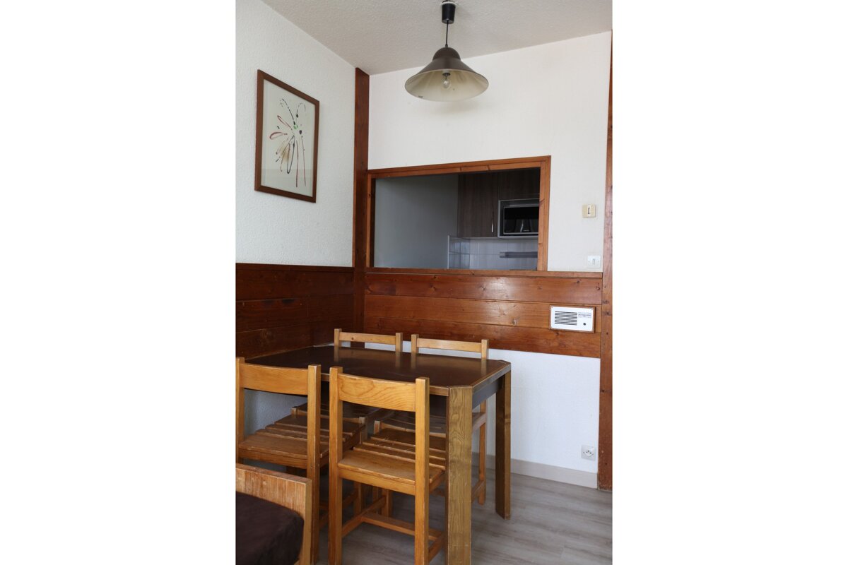 A table and chairs in a room with a picture on the wall