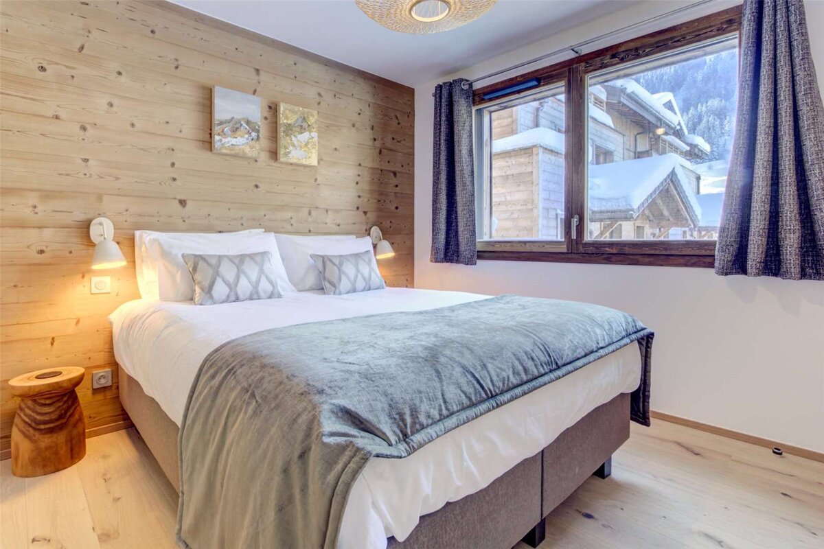 A bedroom with a large bed and a large window