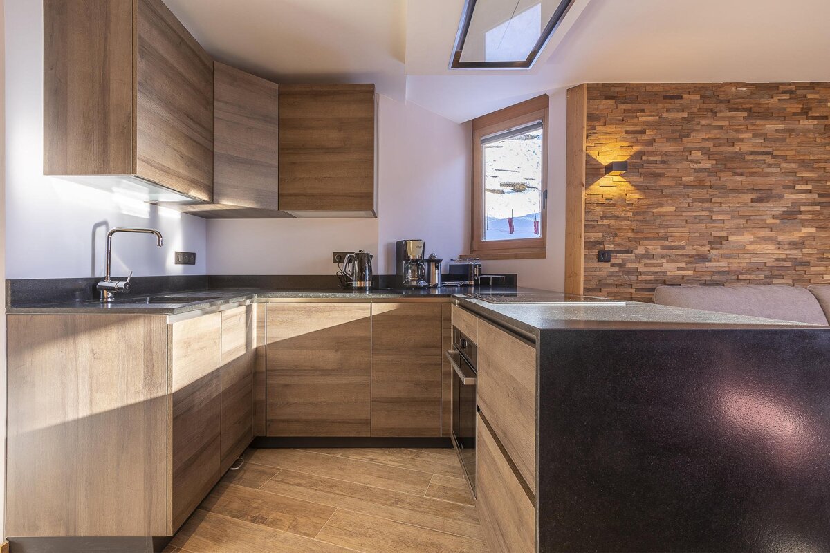 A kitchen with wooden cabinets and a black counter top