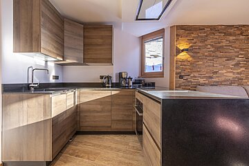 A kitchen with wooden cabinets and a black counter top