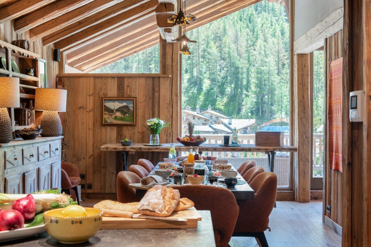 A dining room with a table and chairs and a painting on the wall