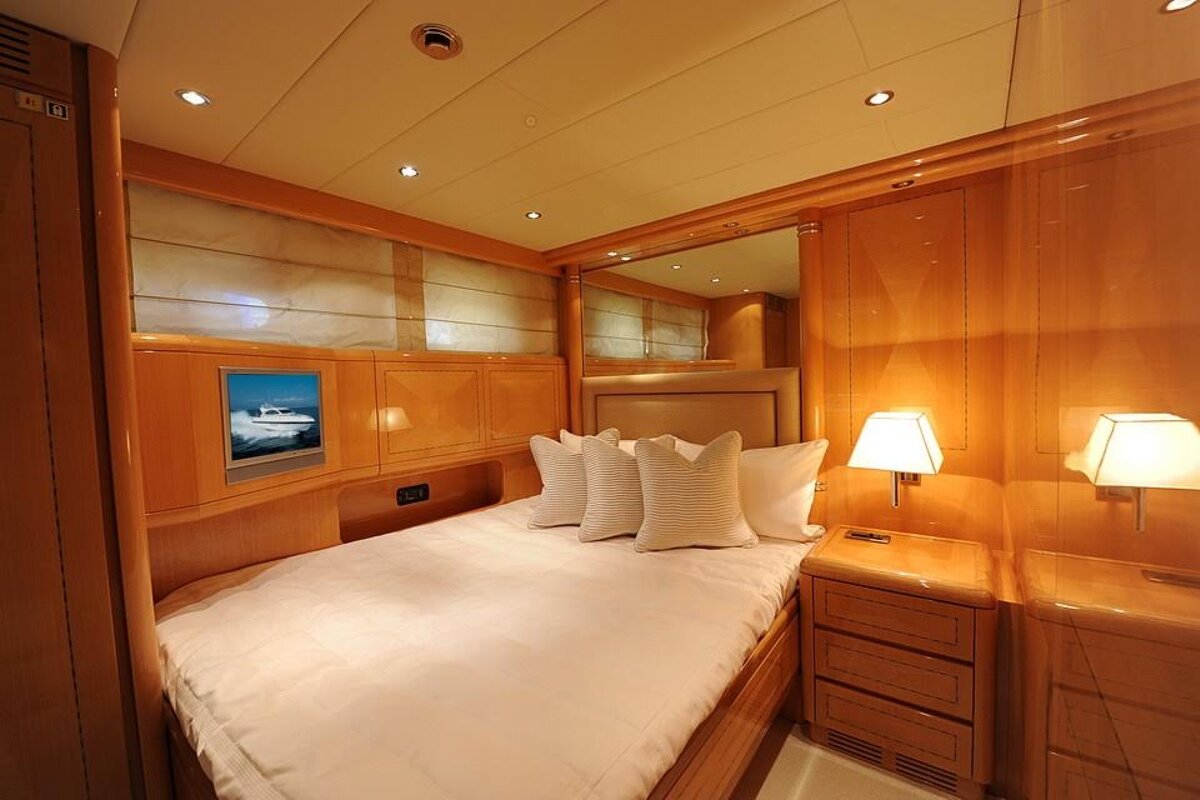 A bedroom with a bed and a television with a boat on it
