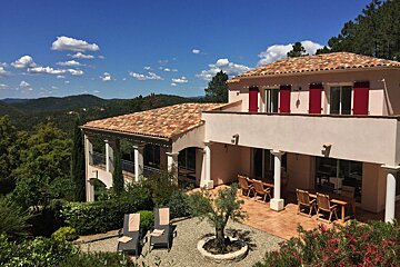 A large house with red shutters on the windows