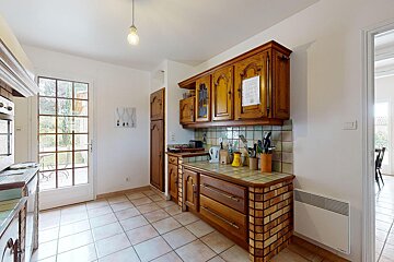 A kitchen with wooden cabinets and tile floors