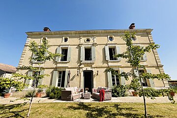 A large house with a lot of windows and shutters