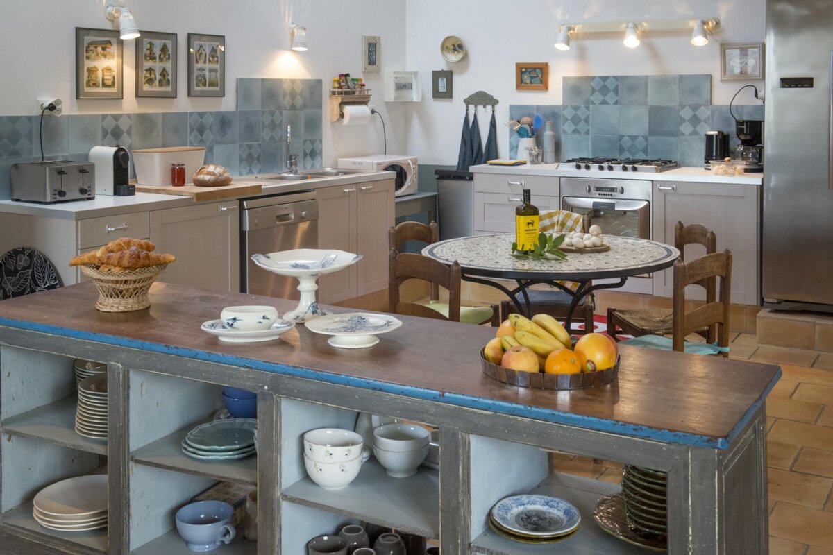 A kitchen with a table and chairs and a bottle of wine on it
