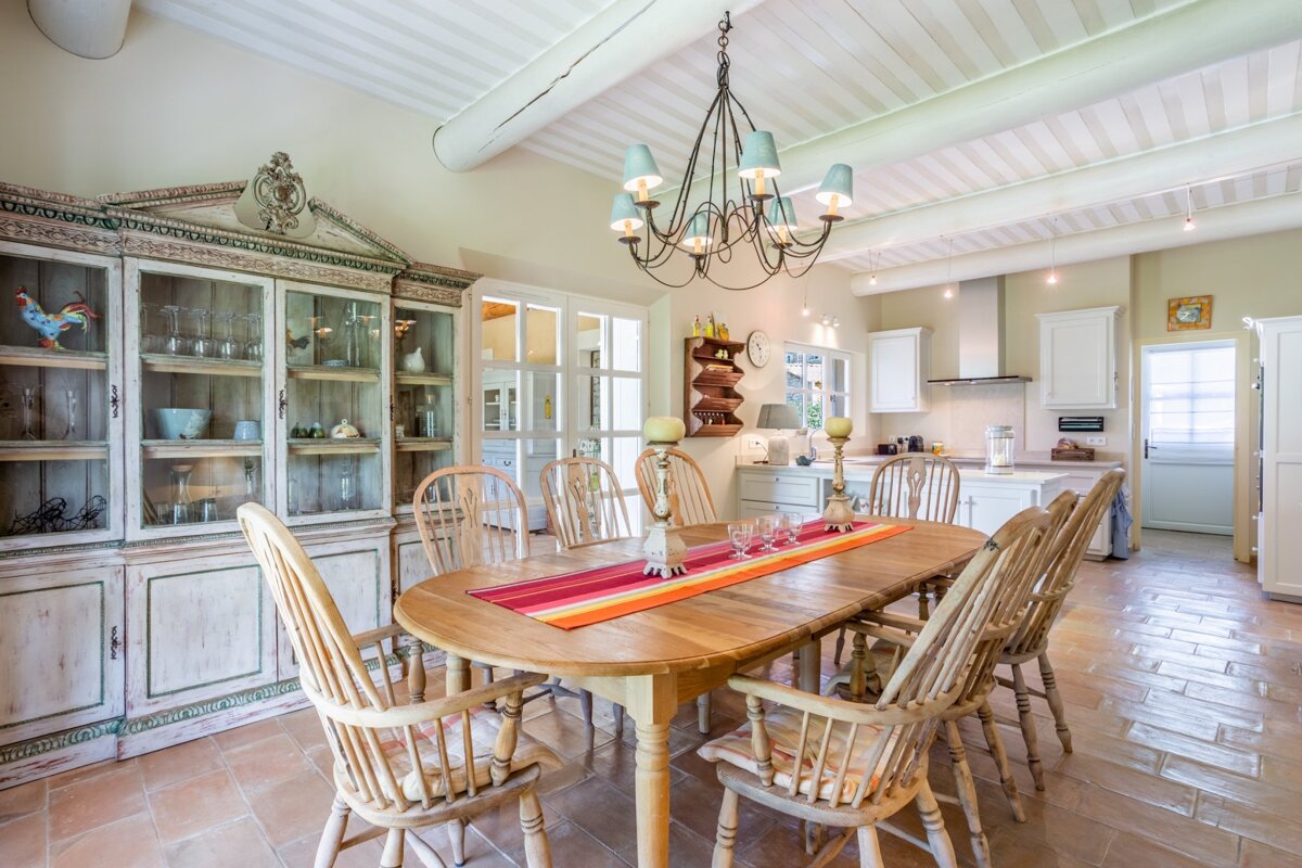A dining room with a table and chairs and a chandelier