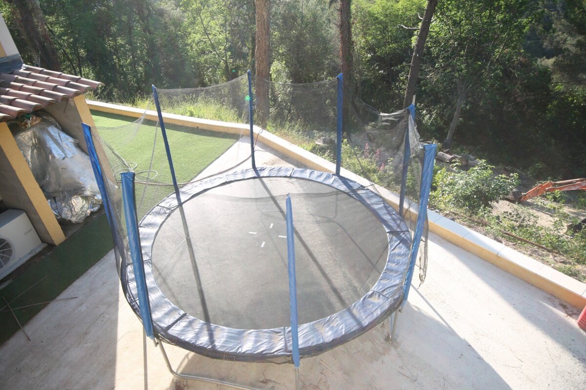 A round trampoline with a blue net around it