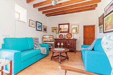 A living room with two blue couches and a television