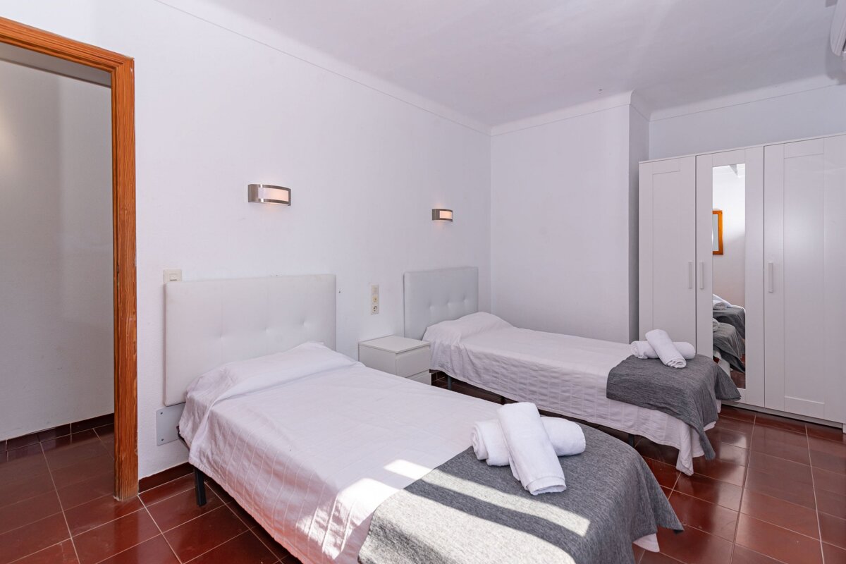 A bedroom with two twin beds and a wardrobe