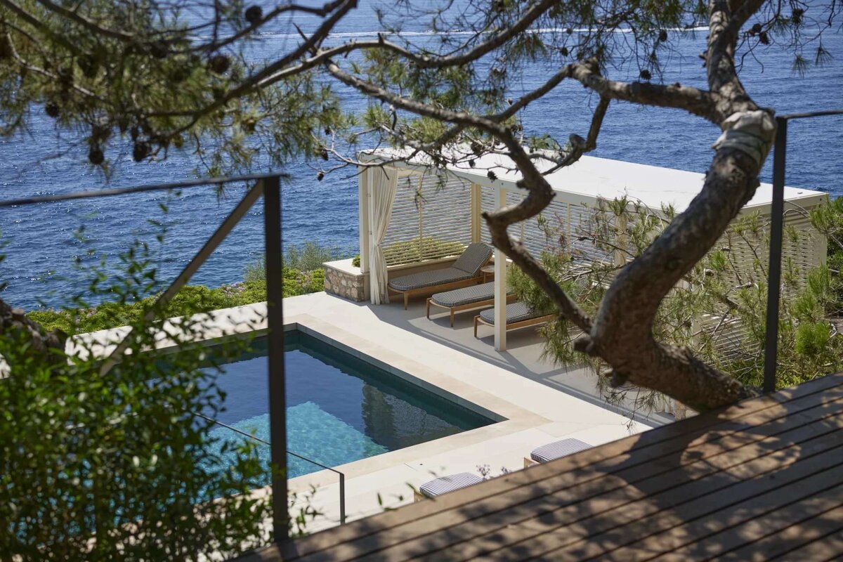 A swimming pool with a pergola overlooking the ocean