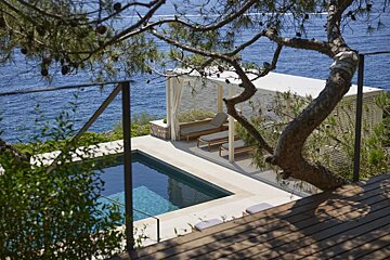 A swimming pool with a pergola overlooking the ocean