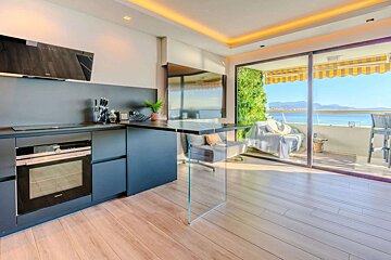 A kitchen with a sliding glass door leading to a balcony