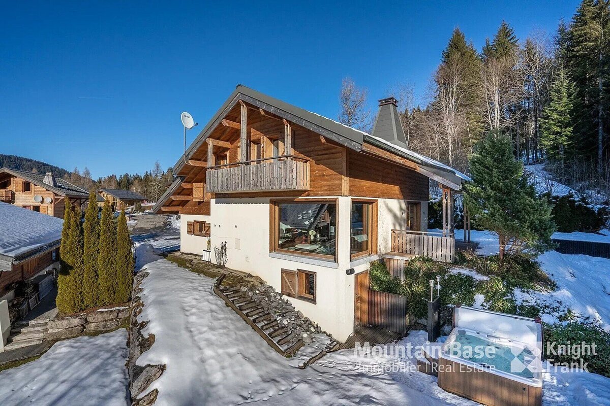 A mountain base real estate logo is on the side of a house