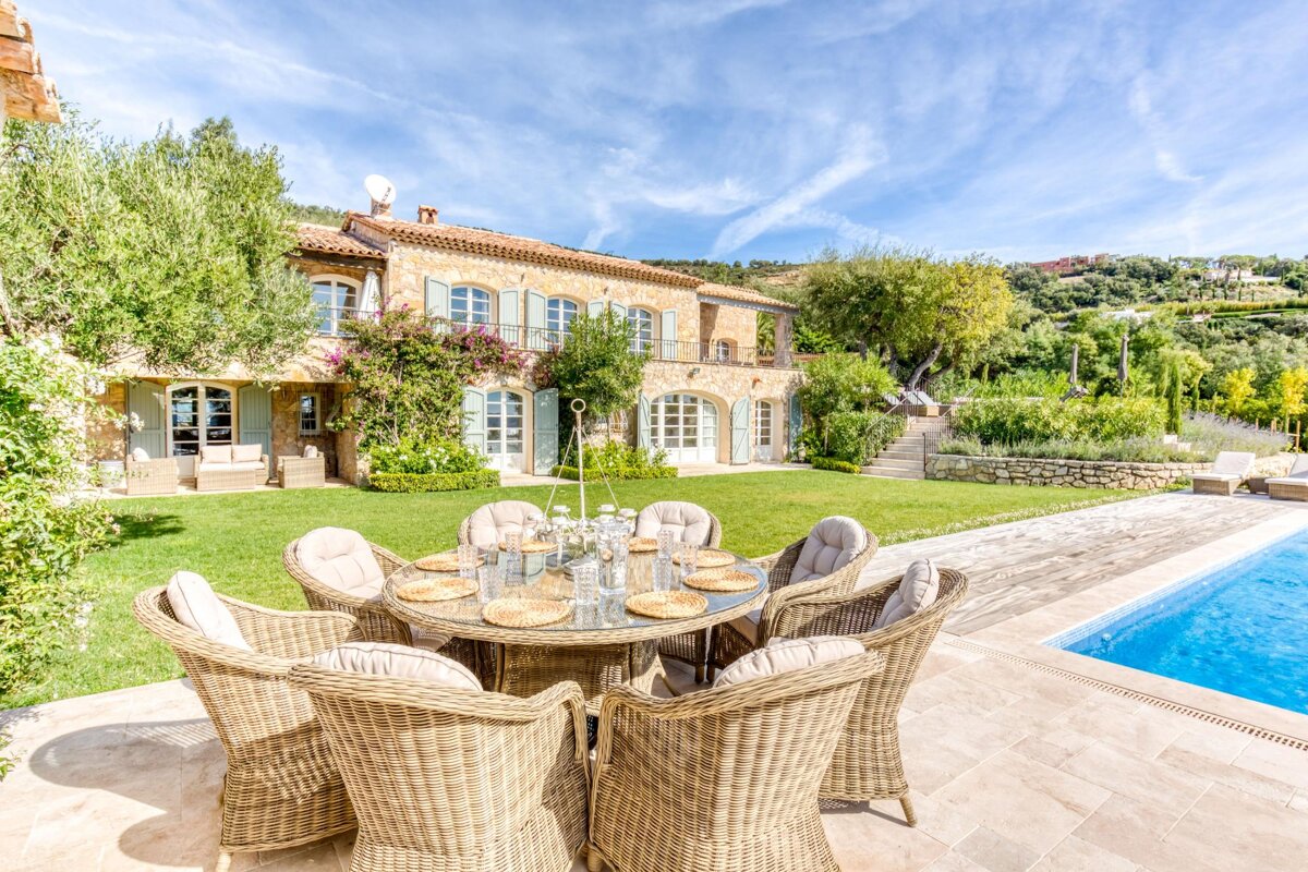 A table and chairs in front of a large house