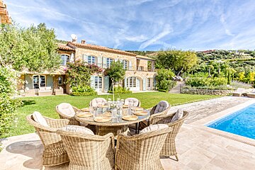 A table and chairs in front of a large house
