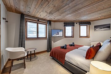 A bedroom with a large bed and a flat screen tv