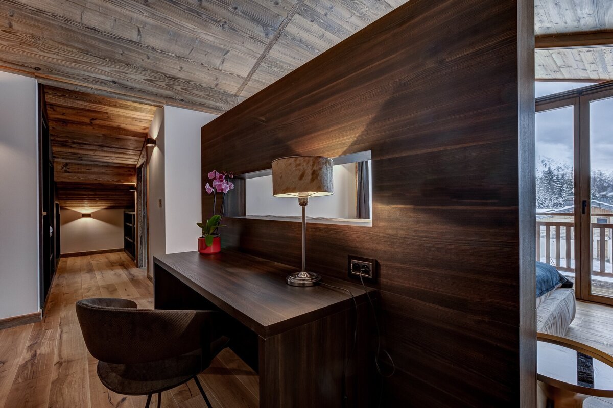 A desk with a lamp on it in a hallway