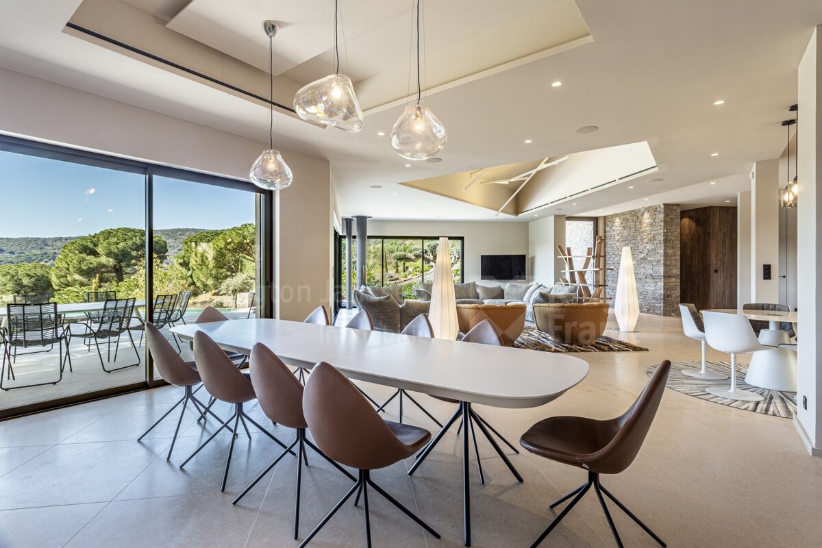 A dining room with a white table and brown chairs