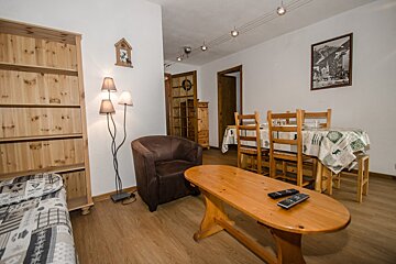 A living room with a chair a table and a picture on the wall