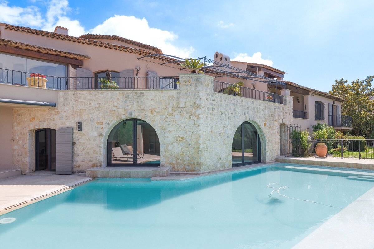 A large house with a swimming pool in front of it