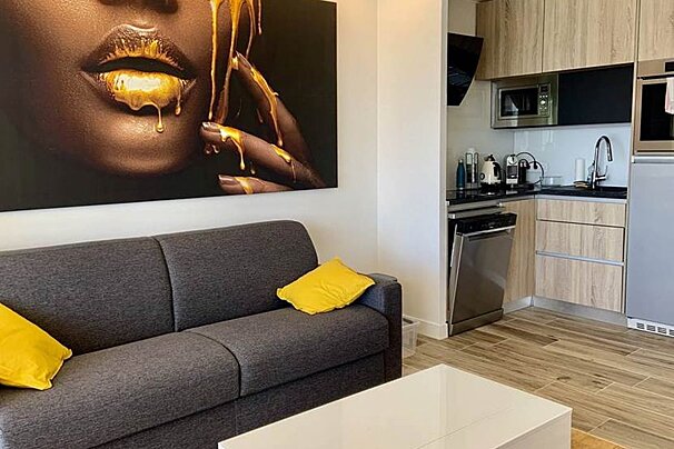 A living room with a couch and a painting on the wall