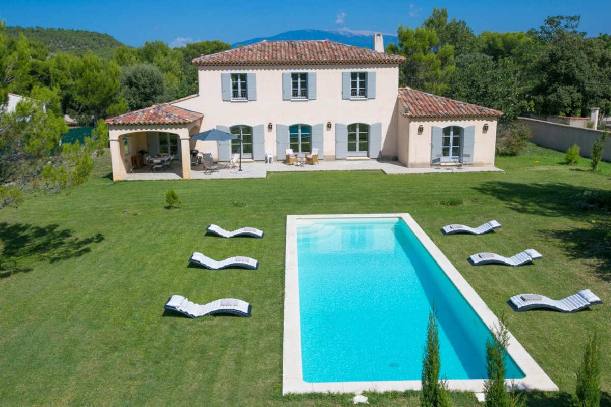 A large house with a large swimming pool in front of it