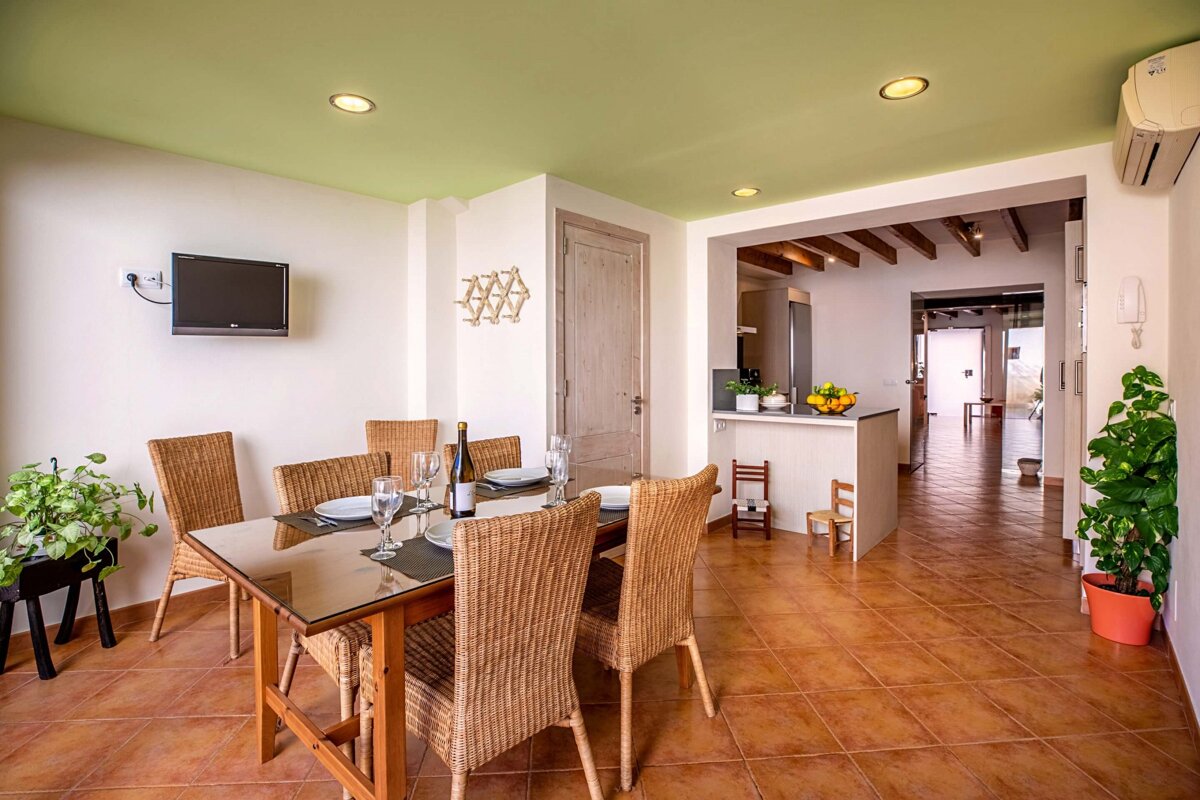 A dining room with a green ceiling and wicker chairs