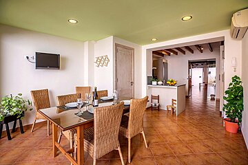 A dining room with a green ceiling and wicker chairs
